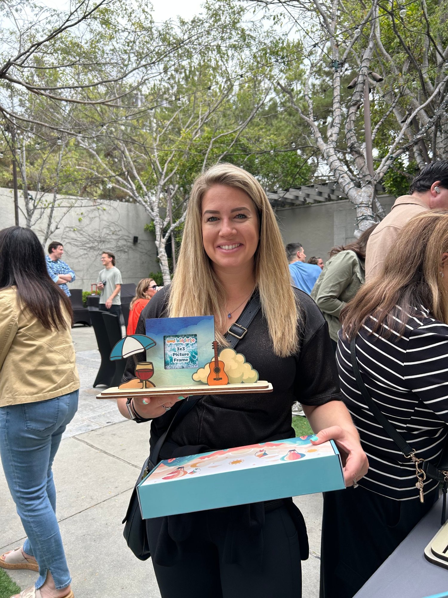 Guest showing her personalized picture frame and gift box at a Blue Sky event